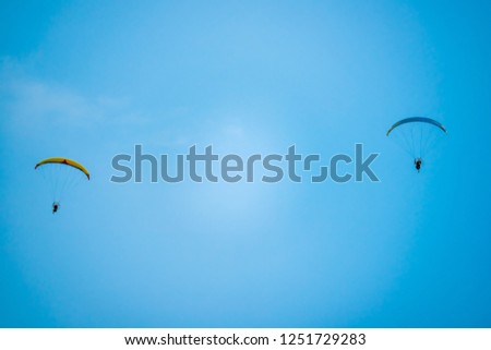 adventure man active extreme sport pilot flying in sky with paramotor engine glider parachute
