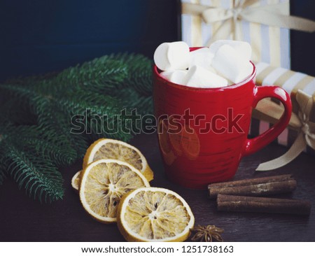 Red cup of coffee or hot chocolate with marshmallow on wooden dark background. Cinnamon sticks, stars with bokeh. Winter concept. Hot coffe with marshmallow. Xmas