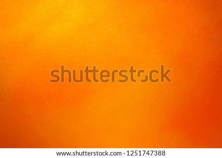 Vintage texture of yellow orange wall for design backdrop. Rumpled concrete wall. Artistic gradient. Illuminated surface. Bright background. Raster image.