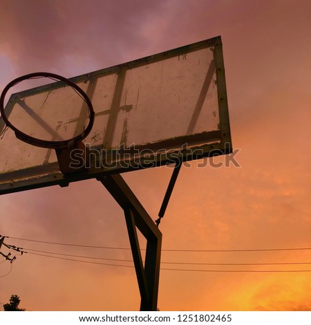 Sunset blended with orange, pink and purple was spread out behind the old basketball backboard.
