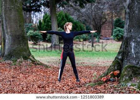 Concept of young lady doing yoga exercises outdoors in the forest.