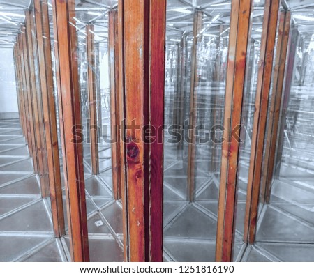 A glass maze on an amusement funfair, seeking the way out in a house of mirrors, copy space, selected focus 