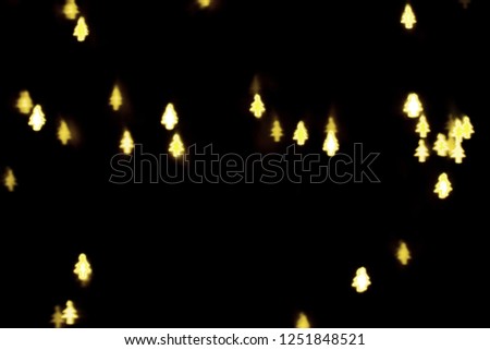 Abstract picture of colorful lights in bokeh glowing in shape of tree on isolated black background. Christmas and New Year party concept