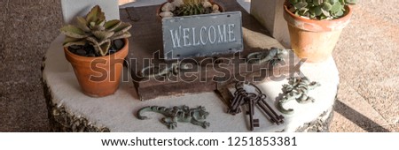 Metal Sign Welcome on the old well with wooden lid