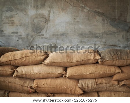 Jute Gunny bags hemp sack textile fully of paddy rice lean on the concreat wall background in thailand  Royalty-Free Stock Photo #1251875296