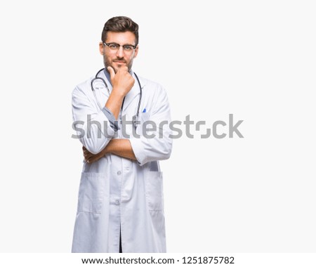 Young handsome doctor man over isolated background looking confident at the camera with smile with crossed arms and hand raised on chin. Thinking positive.
