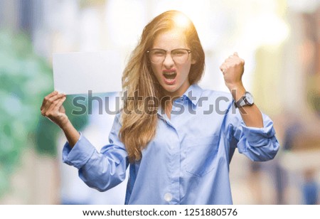 Young beautiful blonde business woman holding blank card over isolated background annoyed and frustrated shouting with anger, crazy and yelling with raised hand, anger concept