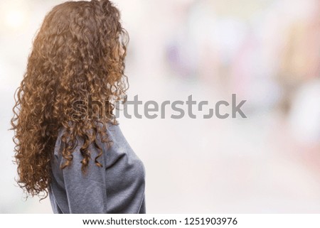 Beautiful brunette curly hair young girl wearing a sweater over isolated background looking to side, relax profile pose with natural face with confident smile.