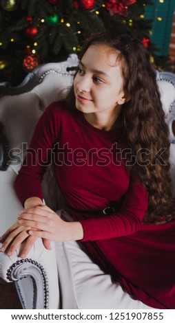 Portrait of a beautiful girl. Close-up. Brunette with flowing hair, Young girl.Teenager.
portrait of a beautiful teenager girl sitting on a white chair in Christmas.
loose hair