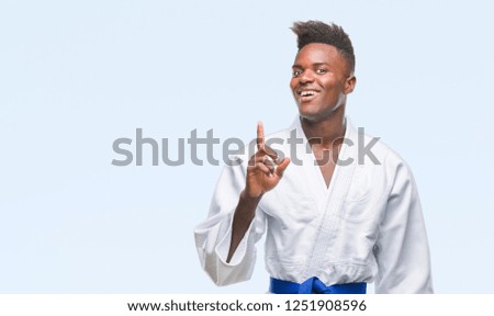 Young african american man over isolated background wearing kimono pointing finger up with successful idea. Exited and happy. Number one.