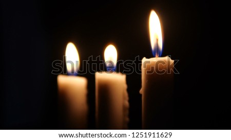Footage of candles are lit in the darkness. Christmas