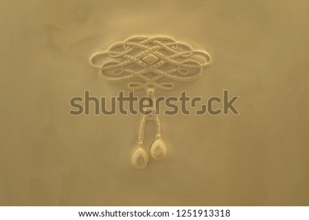 Golden Creme Necklace on a Plaster Backdrop.
