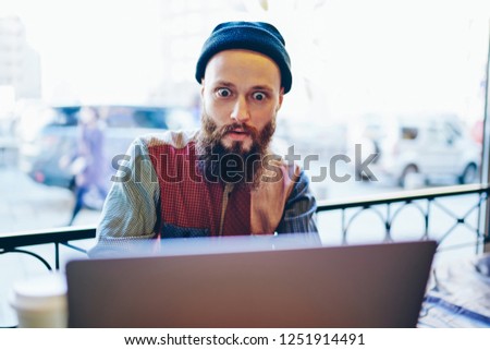 Caucasian amazed man feeling shocked of receiving email from company about opportunity for working remotely, excited male freelance with expression on face reading surprised message from friend