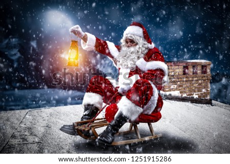 Red old Santa Claus on roof and winter night. 