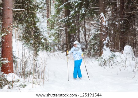 Female skier turning back skiing in winter forest