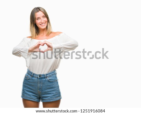 Young beautiful woman over isolated background smiling in love showing heart symbol and shape with hands. Romantic concept.