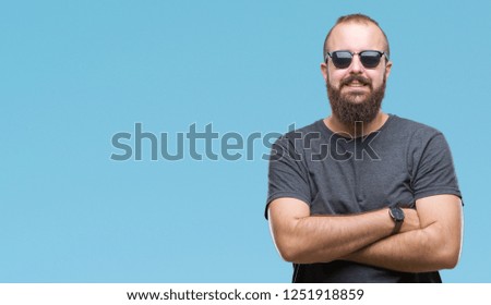 Young caucasian hipster man wearing sunglasses over isolated background happy face smiling with crossed arms looking at the camera. Positive person.