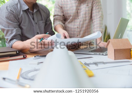 Architects engineer discussing on desk with blueprint. Team group on construction site check documents and business workflow.house model for concept investment mortgage finance and home loan business