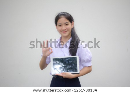 Portrait of thai high school student uniform beautiful girl show tablet