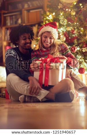 Happy boy and girl exchanging Christmas presents and having fun.
