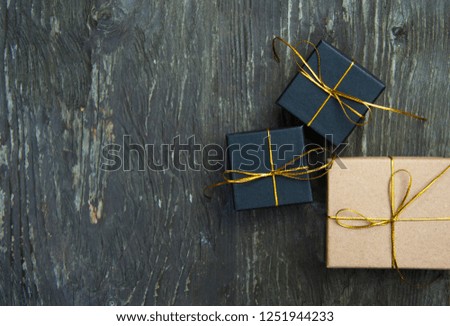 small black gift christmas boxes on rustic wooden background