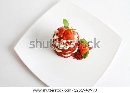 Red velvet cake with strawberry, cream cheese on white plate and background