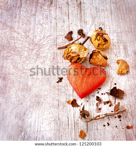 Heart as a symbol of love/vintage card with red heart and dry roses  on grunge old background/valentines day background