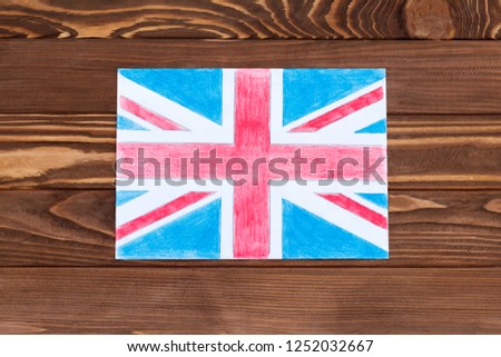 United Kingdom flag on paper, wooden background in old style. there is toning.