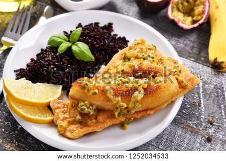 Traditional madeira dish - scabbardfish with bananas and passion fruit Royalty-Free Stock Photo #1252034533