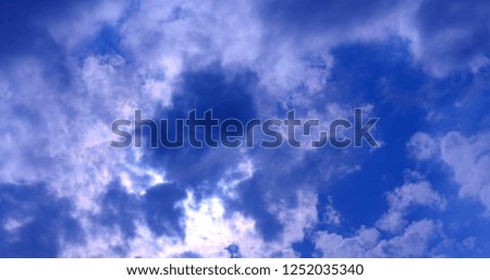 Stormy white clouds on blue sky. Cloudscape background with fluffy cloud on blue summer sky 