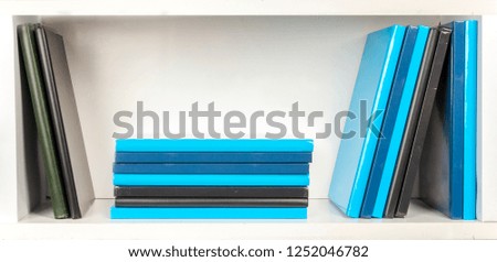 bookshelf - colored (grey, blue and black) books on white shelfs