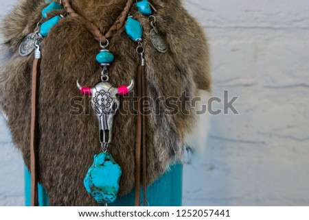 Native american background of animal fur decorated with a necklace with stones and a cow skull