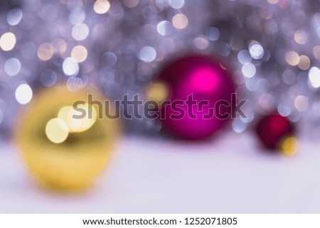 Blurry Christmas background with Christmas balls and bokeh. Three XMAS balls gold and fuchsia.  New Year celebration
