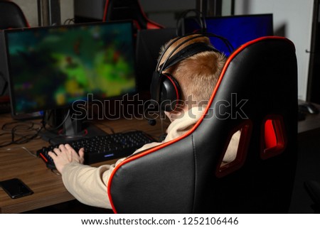Professional cyber sportman trains for the championship. Male hooded gamer playing online game on pc computer Gaming Club. Royalty-Free Stock Photo #1252106446