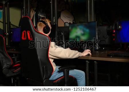 Professional cyber sportman trains for the championship. Male hooded gamer playing online game on pc computer Gaming Club. Royalty-Free Stock Photo #1252106467