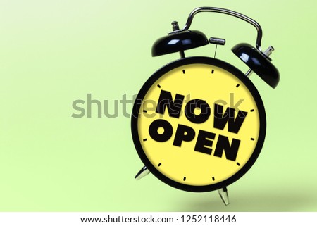 Now open. Black alarm clock with yellow clock face on green background. Shop banner, pistachio poster, store promotion