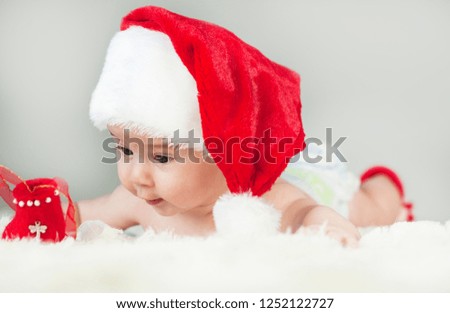 Happy newborn girl in santa hat. New Year and Christmas