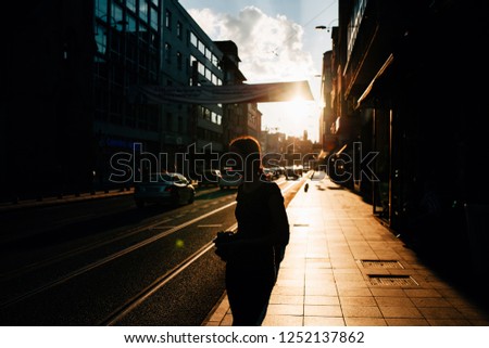 Silhouette of a young woman photographer looking her pictures at Sarajevo streets