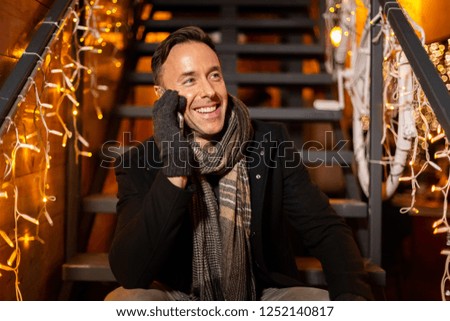 Happy man talking on cell phone at Christmas market, Zagreb, Croatia.