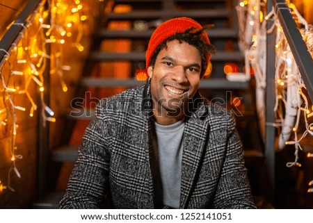 Portrait of african american man sitting on stairs at Christmas market, Zagreb, Croatia.