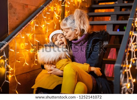 Mother kissing cheek of daughter at Christmas market, Zagreb, Croatia.