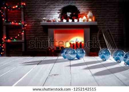 A winter composition on a wooden table in the glow of a fireplace and a Christmas tree decoration on a magical evening 