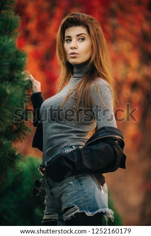 Photo of young brunette in autumn park
