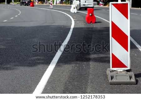 road fence rectangular white-red striped sign warning of repair work.