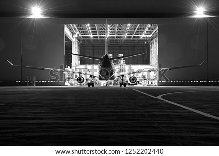 Aircraft parking for maintenance before flight at night .Aircraft(airplane)parking in front of aircraft hangar use external power and maintenance by aircraft technician.  Royalty-Free Stock Photo #1252202440