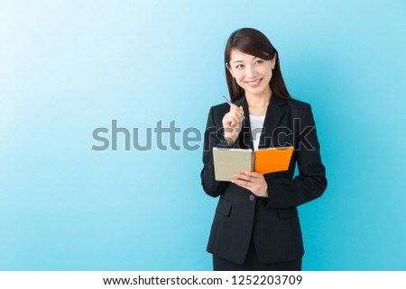 Beautiful young asian woman who fills out a notebook