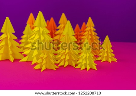 Christmas tree made of yellow craft paper. Handicraft. Violet and pink background. Forest