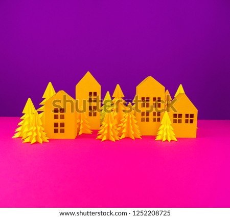 Christmas tree and house made of yellow craft paper. Handicraft . Violet and pink background. Forest