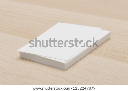 Vertical stack of business cards on wood.