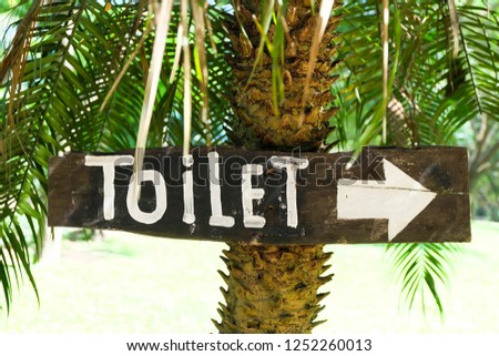 Toilet sign On Wood background.